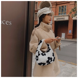 Sac à bandoulière tendance en fausse fourrure florale porté avec un manteau beige