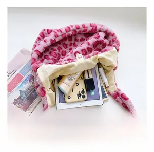 Spacious interior of pink leopard plush tote bag with everyday items and snap closure