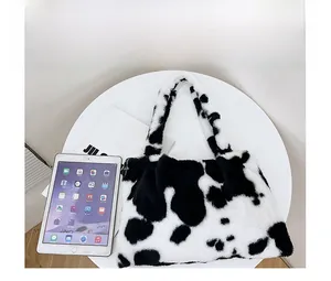 Confronto dimensioni della borsa in peluche maculata accanto a un tablet sul tavolo