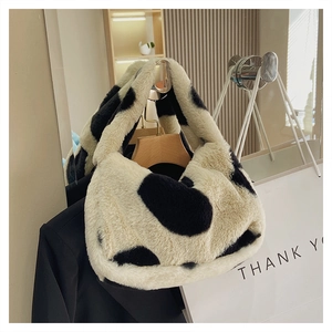 Gros plan d'un sac à main en peluche à motif vache avec une texture douce en fausse fourrure