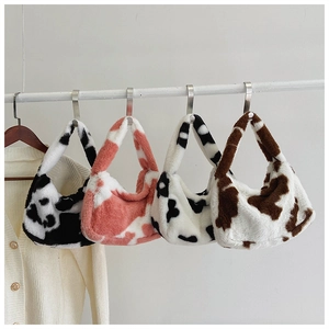 Série de sacs à bandoulière en peluche à motif vache de différentes couleurs sur support