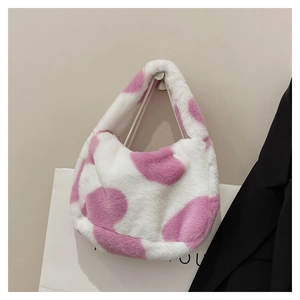 Détail d'un sac cabas en peluche douce avec un motif de vache rose pour l'automne et l'hiver
