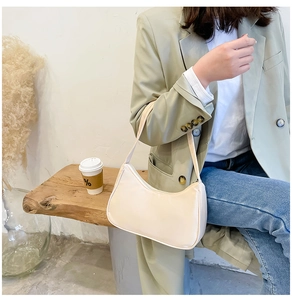 Minimalist beige nylon half-moon shoulder bag styled with casual urban outfit