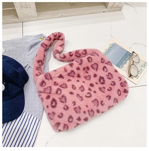 Vue détaillée à 45 degrés d'un sac à bandoulière en peluche rose avec motif léopard à cœurs