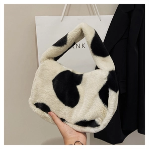 Vue détaillée du sac à main en peluche à motif vache avec texture élégante en fausse fourrure