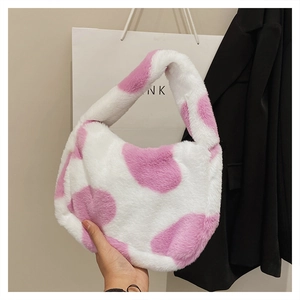 Détail du sac à main en peluche rose et blanc à motif vache pour l'automne et l'hiver
