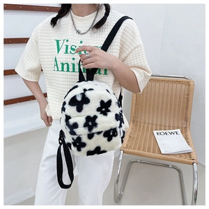 Détail du sac à dos en peluche à fleurs noires et blanches avec texture en fausse fourrure