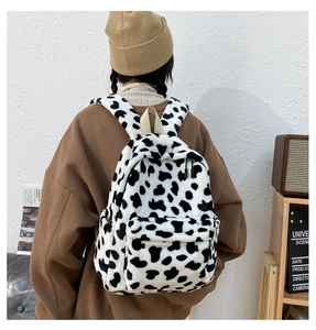 Dettaglio dello zaino in peluche con stampa mucca con tasca zip indossato da modella