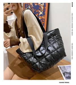 Close-up of black quilted puffer tote bag with glossy finish and spacious side view
