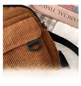Nahaufnahme der braunen Cordstoff-Struktur mit schwarzem Riemen-Detail an einem Damen-Rucksack