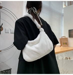 Detail einer weichen weißen Kunstfell-Umhängetasche mit Plüsch-Kuhmuster auf einem Model