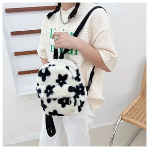 Détail d'un sac à dos floral en peluche douce avec fines bretelles tissées noires