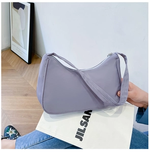 Close-up of light purple nylon crescent bag with smooth zipper and fabric strap