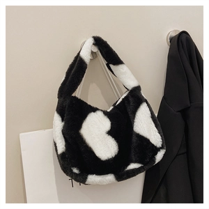 Détail du sac à main en fausse fourrure avec motif vache noir et blanc et anse douce