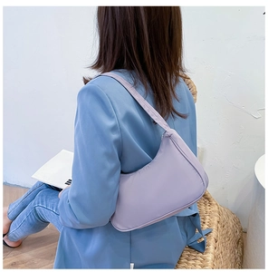 Back view of a model wearing the light purple nylon hobo bag with blue suit jacket