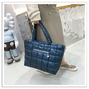 Dettaglio della borsa shopper trapuntata blu scuro con finitura lucida e tasca a zip