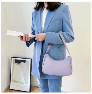 Chic lavender nylon crescent shoulder bag styled with a blue blazer for casual wear