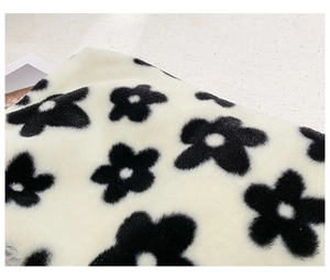 Gros plan sur le tissu en peluche blanc doux avec des motifs floraux noirs élégants