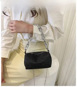 Detail of black rhinestone cylinder bag with metallic chain and sparkling crystals