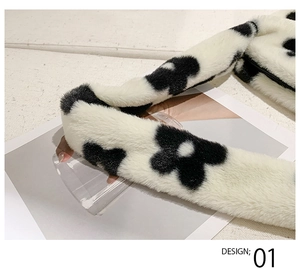 Détail de la bandoulière épaisse sur un sac en peluche à motif floral noir et blanc doux
