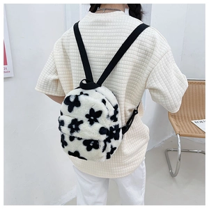 Détail de la bandoulière réglable et texture pelucheuse à fleurs du sac à dos blanc