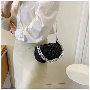 Detail view of black rhinestone cylinder bag with chunky silver chain on model
