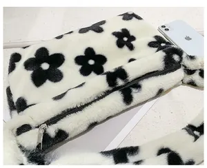 Détail du sac à épaule en peluche avec motifs floraux noirs et texture douce