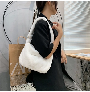 Modell mit weißer Plüsch-Schultertasche mit dickem Kunstfellriemen und Metallringen