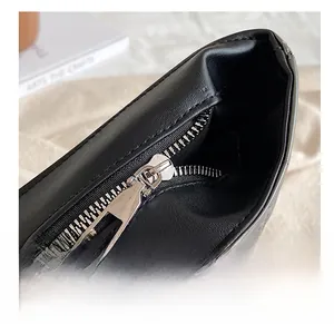 Close-up of smooth silver metal zipper on premium black puffer bag with fine texture