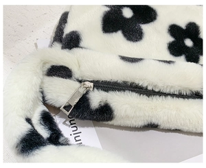 Gros plan détaillé du sac en fausse fourrure à fleurs noir et blanc avec zip argenté