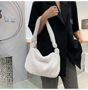Detail einer weichen weißen Kunstpelz-Schultertasche mit goldenen Ringverbindern