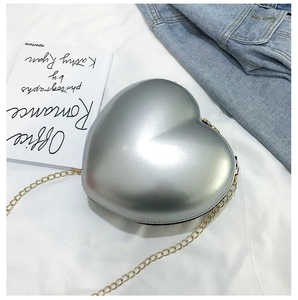 Detailed macro view of heart-shaped silver metallic mini bag with elegant gold chain strap