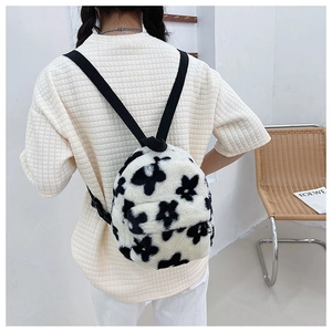 Gros plan du sac à dos en peluche à fleurs avec bretelles noires et fermeture éclair