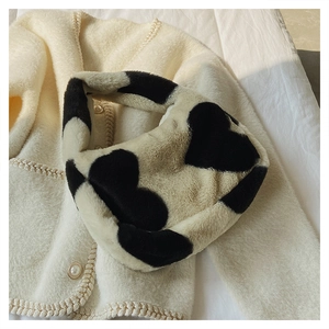 Vue détaillée de la texture en fausse fourrure et du motif cœur noir du sac peluche