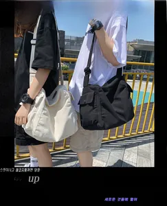 Detail of large canvas messenger bags with flap closure and adjustable straps in street style