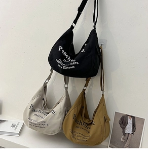 Dettaglio della borsa a tracolla in tela con scritta Peachbloom e tracolla regolabile