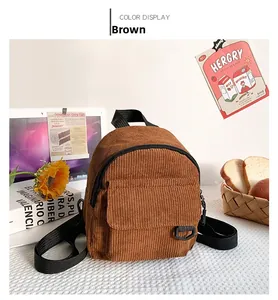 Detailansicht eines braunen Cord-Mini-Rucksacks auf einem Schreibtisch mit Blumen
