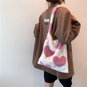 Vista laterale di una borsa tote in peluche con cuori viola su pelliccia sintetica