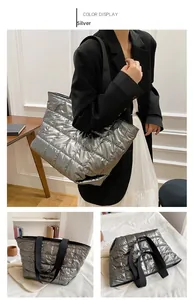 Detail view of silver quilted puffer tote bag with black strap and large capacity