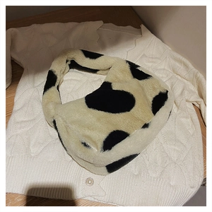 Gros plan sur la texture du sac en fausse fourrure à imprimé vache sur pull blanc