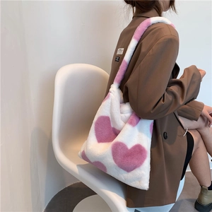 Dettaglio della borsa tote in peluche bianco con motivi a cuore rosa in morbido tessuto