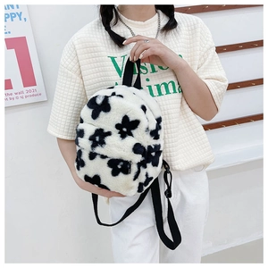 Détail d'un sac à dos en peluche à fleurs noir et blanc avec texture en fausse fourrure