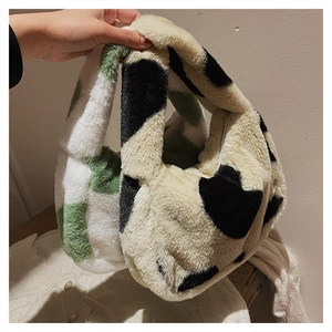 Détail du sac à main pelucheux à motif vache montrant la texture douce et la fermeture