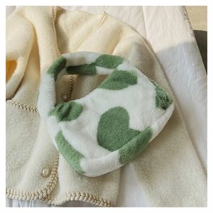 Détail d'un sac à main en peluche à imprimé vache verte avec poignée supérieure épaisse