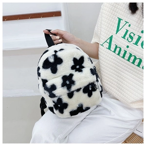 Détail d'un mini sac à dos en peluche à fleurs noir et blanc avec fermeture éclair argentée