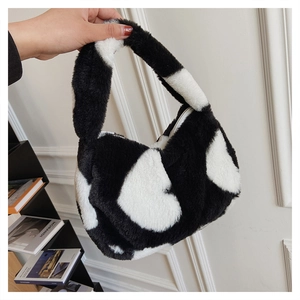 Vue détaillée du sac à main en fausse fourrure avec motif de cœur noir et blanc et texture