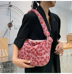 Seitenansicht einer rosa Plüsch-Achseltasche mit Leopardenmuster, von Modell getragen