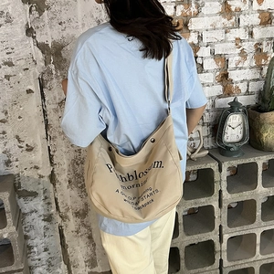 Borsa a tracolla in tela beige con scritte nere artistiche per uso quotidiano