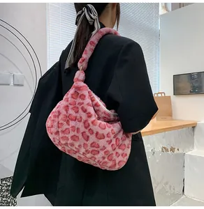 Detailansicht der pinkfarbenen Plüschtasche mit Leopardenmuster auf einem schwarzen Blazer