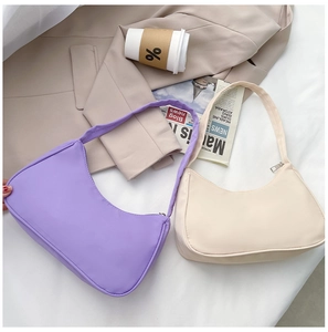 Detail shot of purple and beige nylon hobo shoulder bags in a minimalist lifestyle setting